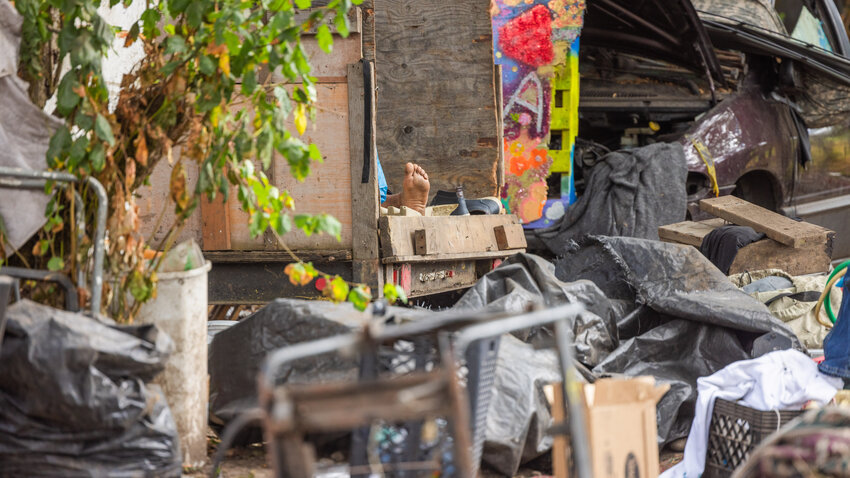 A foot is seen in the back of a trailer as a group of people sleep at the Blakeslee Junction encampment at the end of Eckerson Road in Centralia on Wednesday, Aug. 30.
