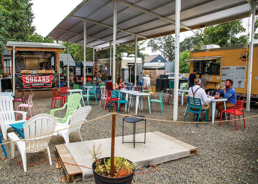 Food cart visitors enjoy meals from Sushi Kato and Little Conejo Norte on Aug. 9 in Ridgefield. The food cart pod in Ridgefield also features Sugars Barbecue and Little Cantina.