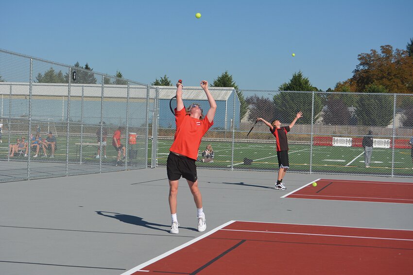 Freshman Emery Clary (center) and junior Nathanial Hensley (right) serve against North Thurston on Sept. 15.