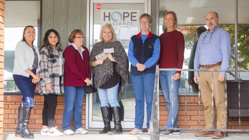 From left, Rosio Casimiro, Darlene Purl, Kathy Halsan, Kris Camenzind, Laura Hewett, Robin Warren and Patrick Morrison smile for a photo on Friday in Centralia as Hope Alliance receives $500 in cash and a check for over $2,000 from money raised during the LunaFest Film Festival hosted by the American Association of University Women in April.