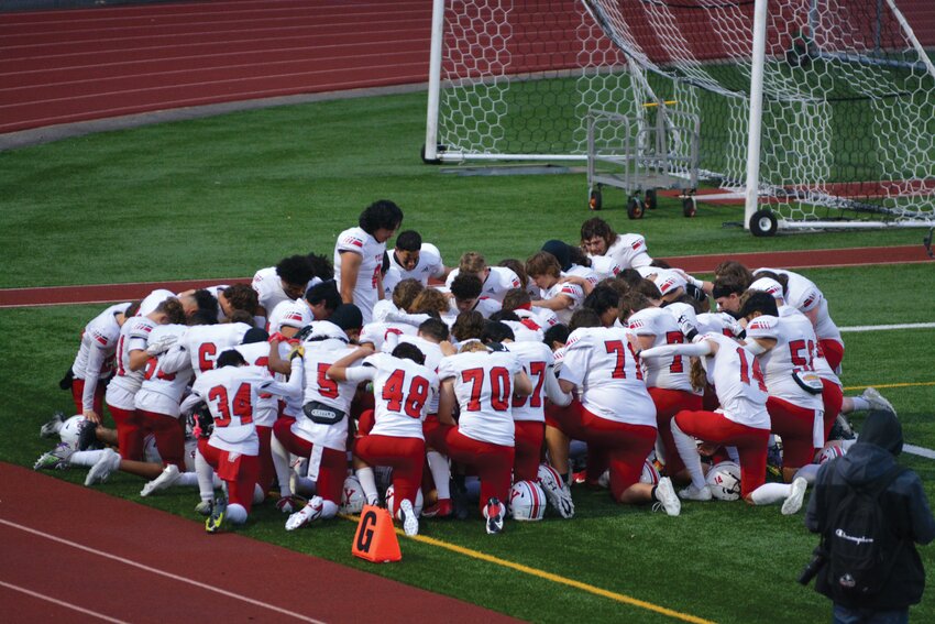 Senior quarterback and team captain Damian Aalona leads the team in prayer on Sept. 28 prior to the team&rsquo;s contest against North Thurston.
