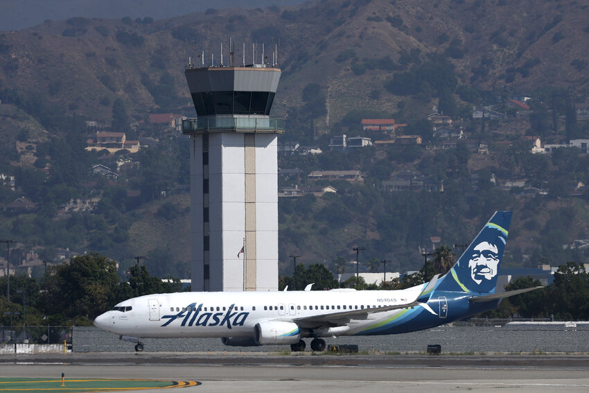 The control tower at Hollywood Burbank Airport stands over an Alaska Airlines plane as it taxis on September 25, 2023 in Burbank, California.