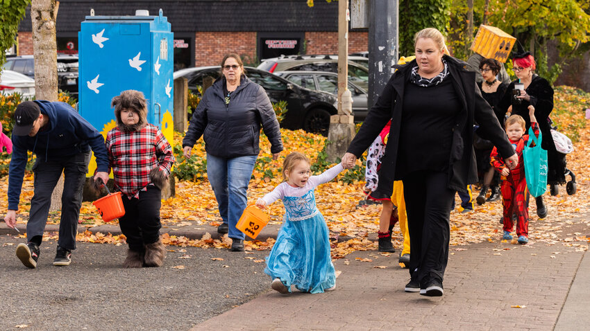 Werewolves, witches, heroes and villains cross West Main Street on Halloween in downtown Centralia Tuesday, Oct. 31.