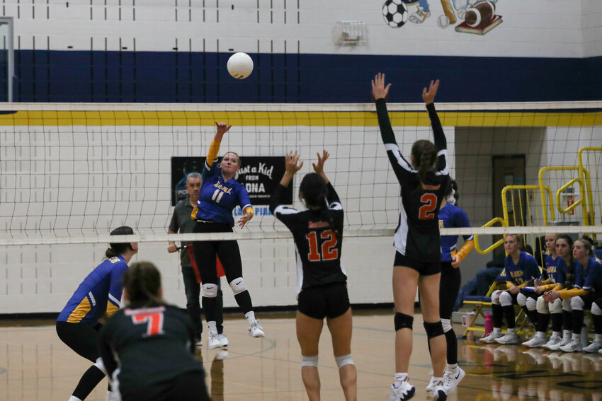 Kendall Humphrey hits the ball over two Rainier defenders during Adna's 3-0 win over Rainier in a 2B District 4 semifinal on Nov. 1 at Adna.
