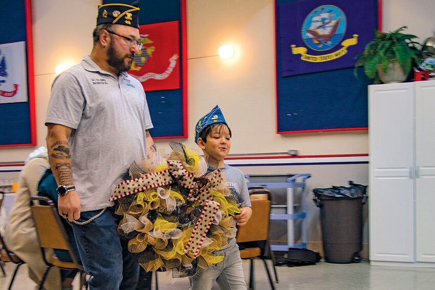 Legionnaire and U.S. Army veteran Antonio &quot;TJ&quot; Mendez carries a wreath with his son, Kiason Mendez-Martinez, during the Grant Hodge Post 17's Veterans Day wreath laying ceremony in Centralia on Saturday, Nov. 11.