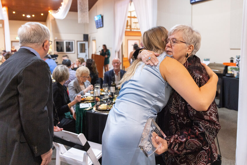 Sue Austin is greeted with a hug after being presented a Legacy Award alongside her husband Mike Austin during the Chehalis Foundation Gala at the Jester Auto Museum Saturday night in Chehalis.