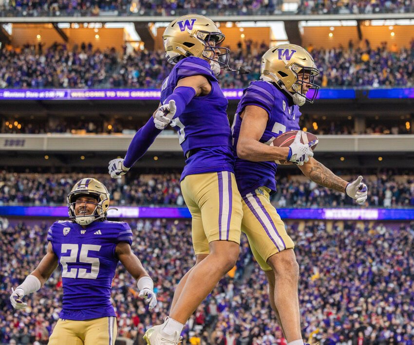 Huskies celebrate with the football after Makell Esteen (24) made an interception during the Boeing Apple Cup Series football game in Seattle against the Washington State University Cougars on Saturday, Nov. 25.