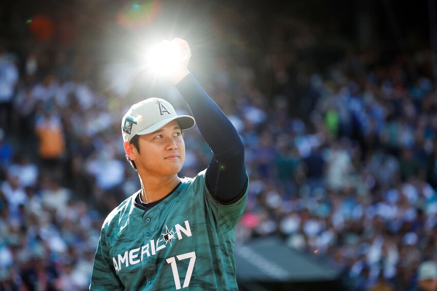 American League pitcher and designated hitter Shohei Ohtani raises a trophy that catches the light during the 2023 MLB All-Star Game July 11, 2023 at T-Mobile Park, in Seattle. Fans in the stands were chanting &ldquo;come to Seattle.&rdquo;