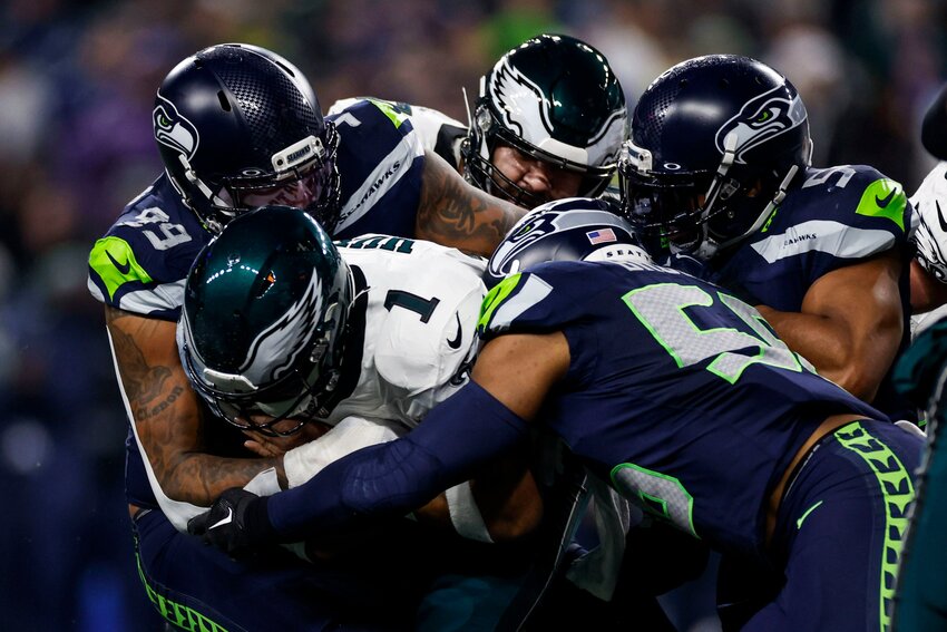 Eagles quarterback Jalen Hurts gets stopped by Seattle Seahawks defensive end Leonard Williams, left, and linebacker Bobby Wagner, right, on the third down in the second quarter of the game against the Seattle Seahawks at Lumen Field in Seattle, Wash. on Monday, Dec. 18, 2023.