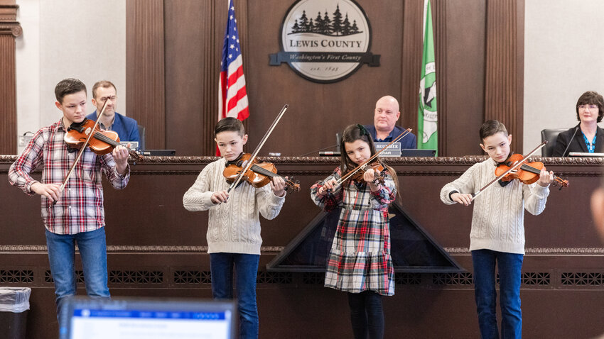 The Kuykendalls, from left, Jud, Joshua, Elsie and Josiah, sing and play music for Lewis County commissioners and attendees during a public meeting inside the Lewis County Courthouse in Chehalis on Tuesday, Dec. 19. The family band was invited to perform for the Board of Lewis County Commissioners.