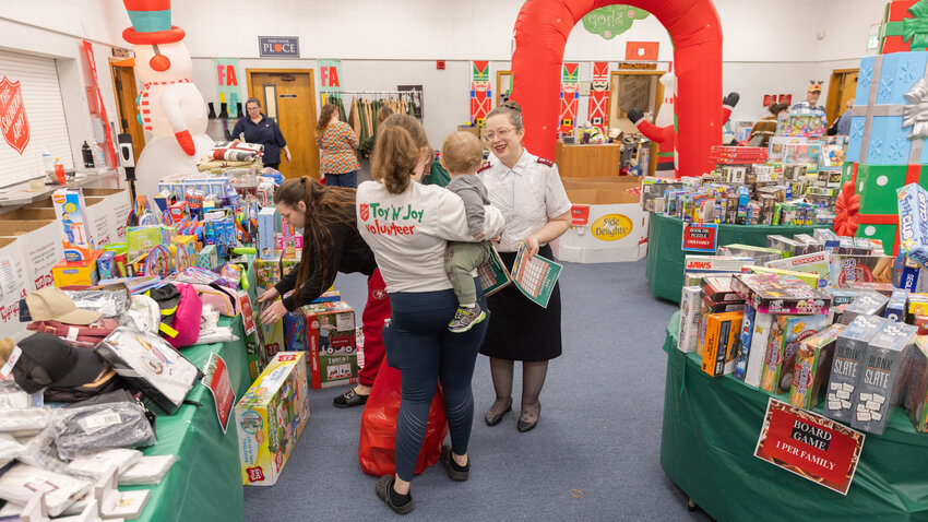 Salvation Army Captain Gin Pack smiles while talking to a baby held by volunteer Riley Pack during a toy drive in Centralia on Tuesday, Dec. 16.