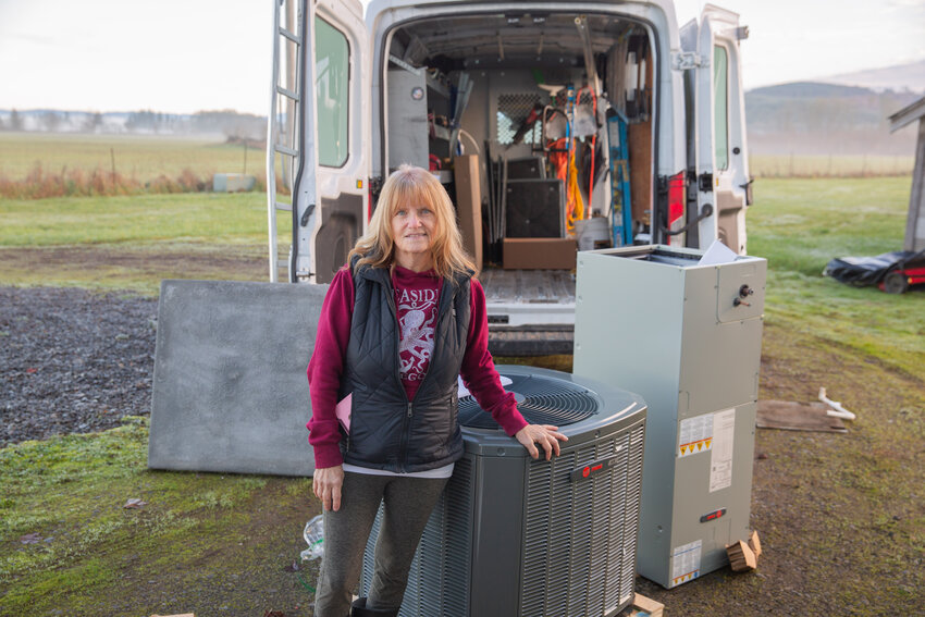 Kim Satcher, a Toledo resident, stands next to her new heating system. Satcher won the system through a contest by Chehalis Sheet Metal.