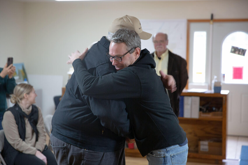 Kevin Aselton, right, hugs Mayor Lonnie Willey, left, upon being greeted during a surprise ceremony at Pe Ell Town Hall Thursday afternoon, Dec. 28.