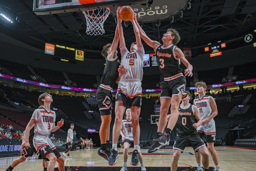 Noah Schow rises up between two defenders during Tenino's loss to Napavine on Dec. 29.