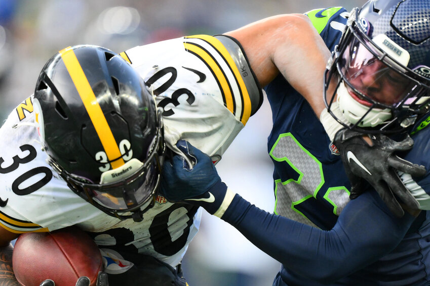 Devon Witherspoon #21 of the Seattle Seahawks tackles Jaylen Warren #30 of the Pittsburgh Steelers during the third quarter at Lumen Field on December 31, 2023 in Seattle, Washington. (Photo by Conor Courtney/Getty Images/TNS)