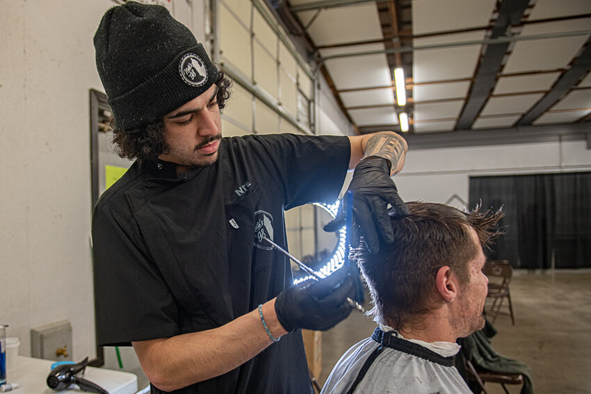 Nathan Rodgiguez, of Nate's '98 Barber Shop in Centralia, gives a free haircut to a visitor of the Project Homeless Connect event in the Blue Pavilion at the Southwest Washington Fairgrounds on Jan. 26