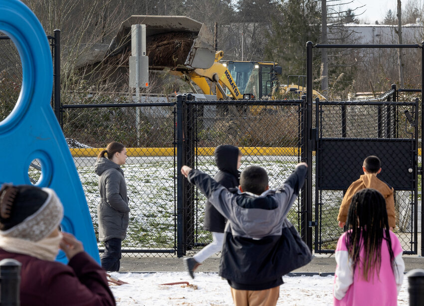 A gravel distribution yard operates without a permit across the street from Fairmount Elementary School as students play at recess, Tuesday, Jan. 16, 2024, in Everett.
