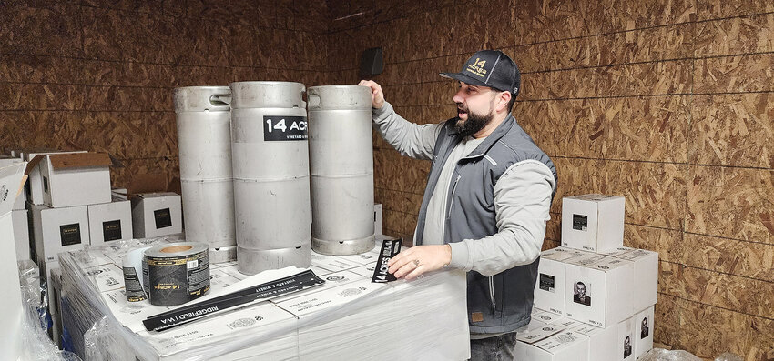 Vineyard and winery owner David Regan labels 5.5-gallon kegs of wine, also known as sixtels.