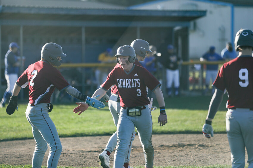 Ross Kelley (3) high-fives Braden Jones after scoring a run during W.F. West's win over Rochester on March 19.