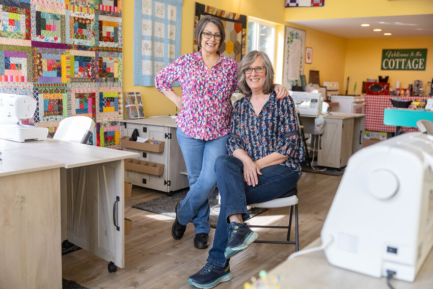 Cat Wallace, left, and Patti Ledesma pose for a photo in the Love Covers studio behind Ledesma&rsquo;s house on Thursday, April 11. Wallace and Ledesma started the nonprofit together in 2021 to bring people together through quilt making.