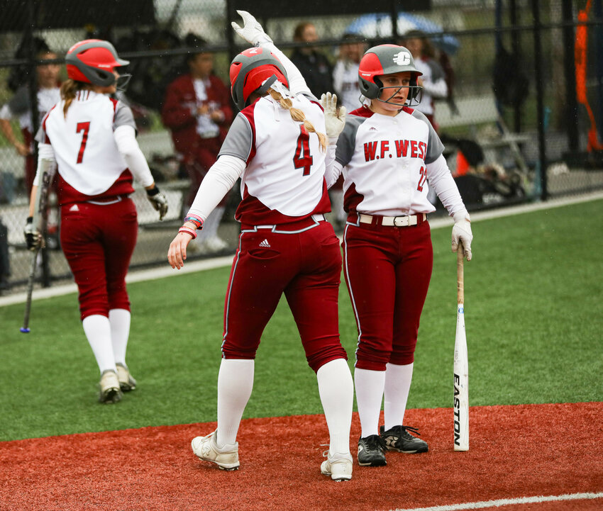 W.F. West's Lena Fragner (4) high fives Avalon Myers after scoring a run against Rochester during an Evergreen Conference game on Friday night at Recreation Park.