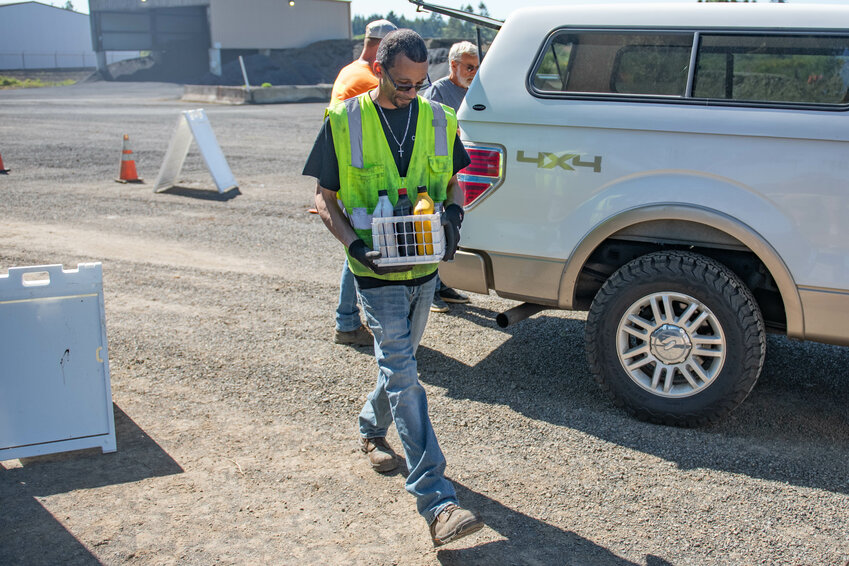 Tim Glover carries a box of used oil to be recycled during a community recycle event on Saturday, May 11, at the Lewis County Public Works Department Road Shop in Napavine.