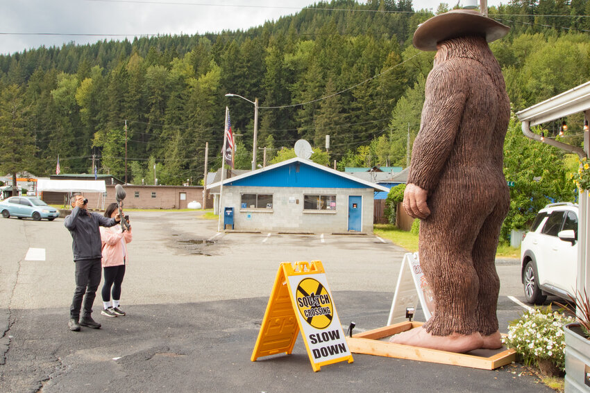 Tourists take photos of the Mount Rainier Bigfoot Howard in front of the Elbe Market Country Story on Wednesday, May 22, in Elbe.