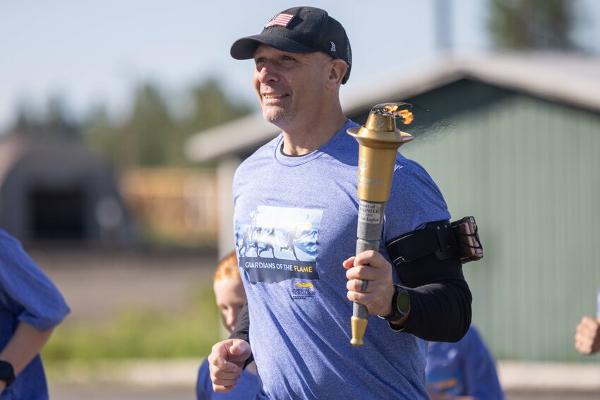 Rep. Peter Abbarno runs with the torch during the Lewis County Special Olympics Law Enforcement Torch Run on Friday, May 31.