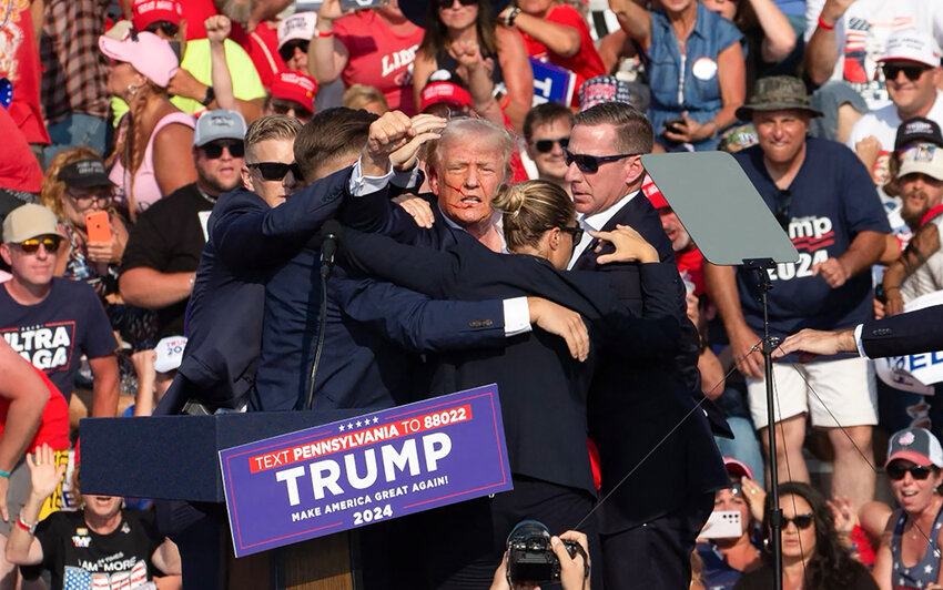 Republican candidate Donald Trump is seen with blood on his face surrounded by secret service agents as he is taken off the stage at a campaign event at Butler Farm Show Inc. in Butler, Pennsylvania, July 13, 2024.