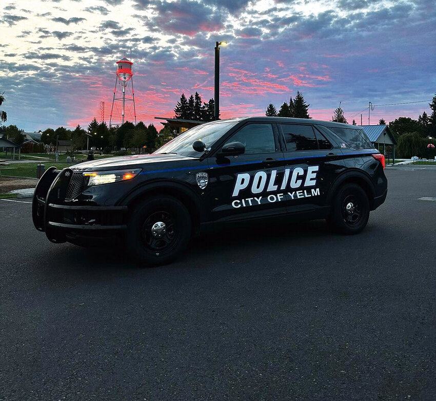 A Yelm police vehicle sits in front of a cotton candy-colored sky near the Yelm Water Tower. Proposed one-time expenditures in 2025, should the City Council approve the budget requests, include police officer training and equipment.