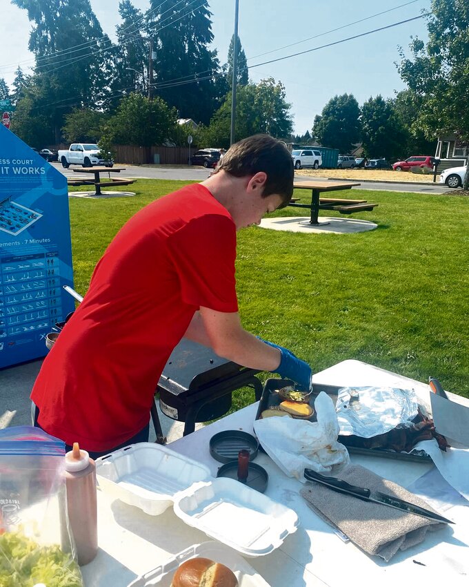 Andrew Sponton works on his &quot;cowboy&quot; burger during the 2024 Nisqually Valley Barbecue Rally Youth Burger Contest at Yelm City Park on July 27.