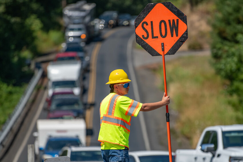 Flagger Luca Pisani holds a stop sign at the end of Chilvers Road in Claquato as WSDOT crews work to repave state Route 6 from Interstate 5 to Adna on Thursday, Aug 1.
