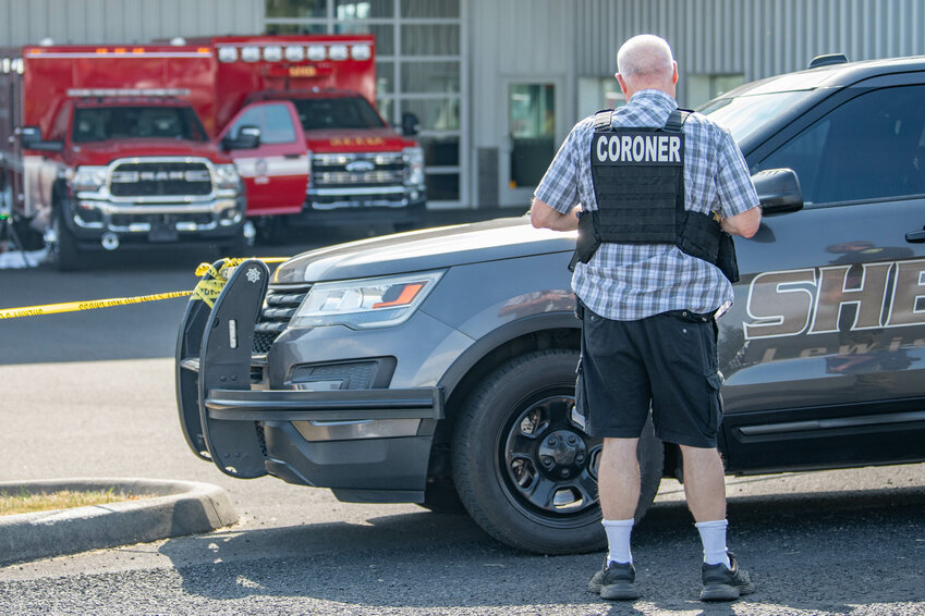 A Lewis County Coroner's Office employee stands at the scene of a fatal incident that took place at Braun Northwest in Chehalis on Friday, Aug. 2.