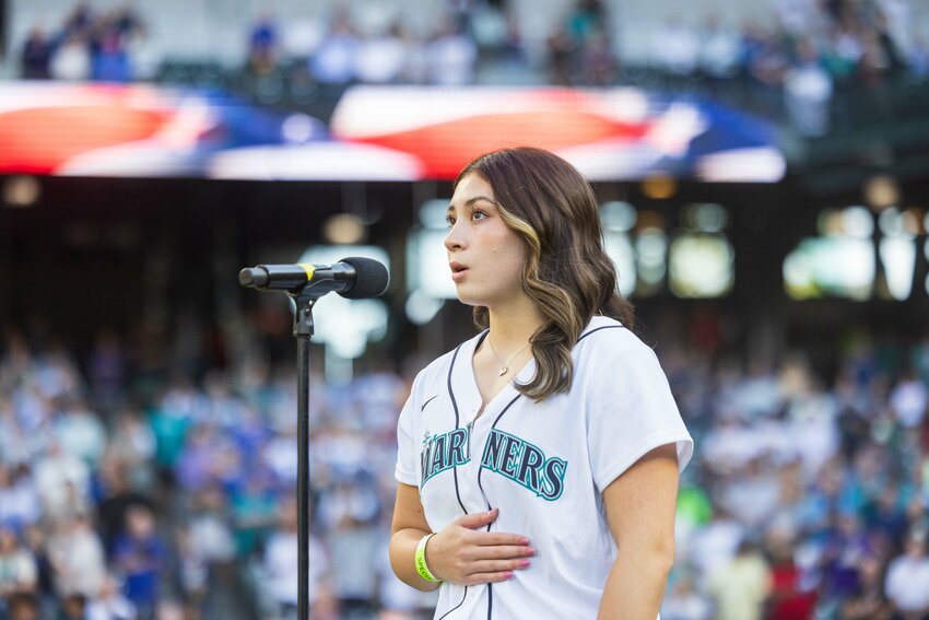 Centralia graduate Chihiro Bringman sings The Star-Spangled Banner before the Seattle Mariners game against the Detroit Tigers at T-Mobile Park on Tuesday, Aug. 6. Bringman started singing when her Poseidon Aquatic Club coaches, Audra Evans and Kelli Denny, asked to sing the National Anthem before a swim meet when she was 10-years-old. Bringman, who graduated this year as a top 10 student at Centralia High School, plans to attend Stonehill College in Boston, Massachusetts, on a swimming scholarship to continue her athletic and collegiate studies. Her performance on Tuesday followed a previous performance of the national anthem at a Tacoma Rainiers game.