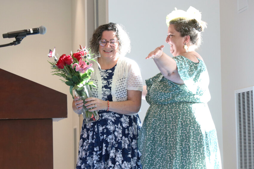 Woman of Distinction Cyndi Philbrook smiles after receiving flowers from 2023 Woman of Distinction Amber Buck on stage at Centralia College&rsquo;s TransAlta Commons during the United Way of Lewis County&rsquo;s Power of the Purse event on Tuesday, Aug. 6.
