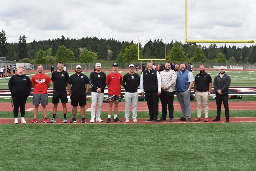 Yelm High School coaches and Dinsmore Auto Group representatives pose for a photo at YHS at Yelm High School Tuesday, Aug. 13, after donating $20,000 in the fundraiser to save C-sports.