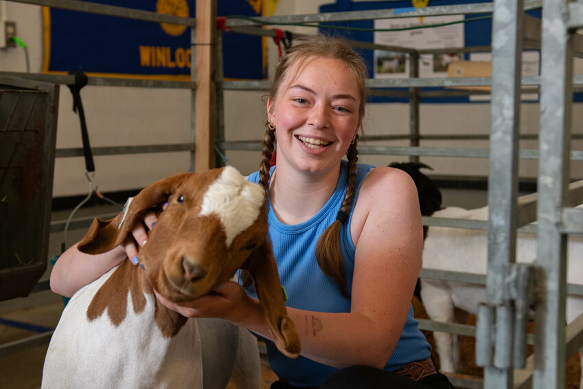 Hailee Turner smiles with her market goat during day 2 of the Southwest Washington Fair on Wednesday, Aug. 14.