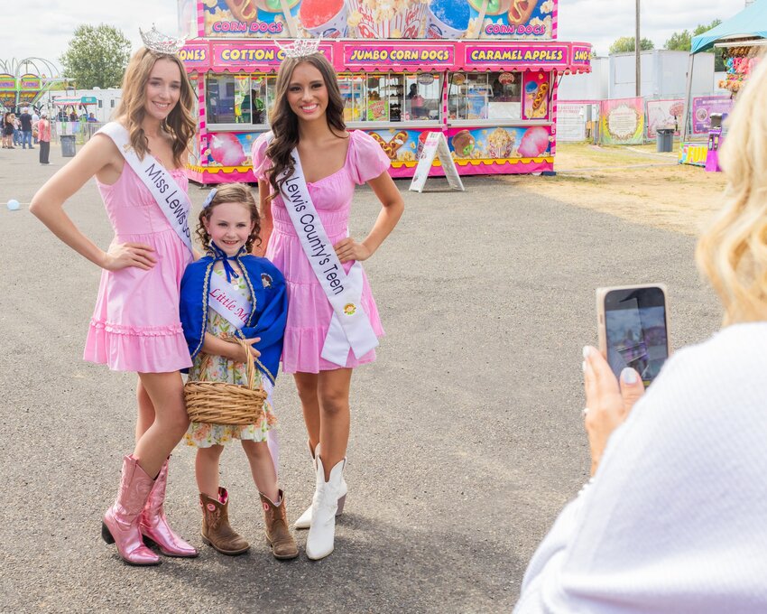 Jared Wenzelburger / For The Chronicle  Little Miss Friendly Hadleigh Westover, 8, of Morton, smiles for a photo with Miss Lewis County Katelynn Guenther, left, and Miss Teen Lewis County Capri O&rsquo;Neill, right, on Wednesday at the Southwest Washington Fairgrounds in Centralia. The fair runs through Sunday.