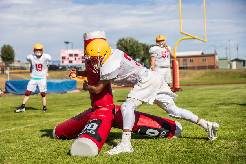 A Winlock player tackles a &ldquo;Quad&rdquo; tackling machine during football practice at Winlock High School on Monday, Aug. 26.