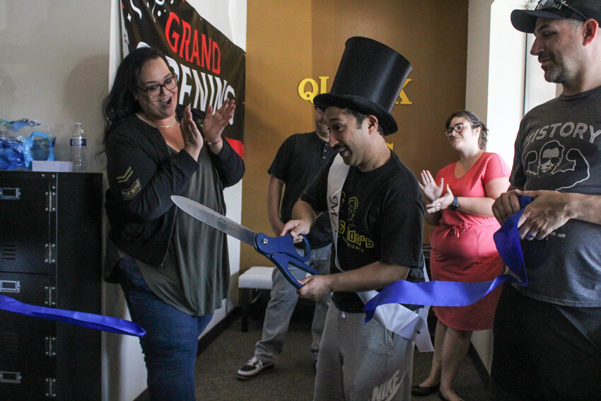 Joe DePinto, donning his mayor top hat and sash, cuts the ribbon to mark the grand opening of Quark &amp; Odo's Escape Room Experience on Aug. 16.