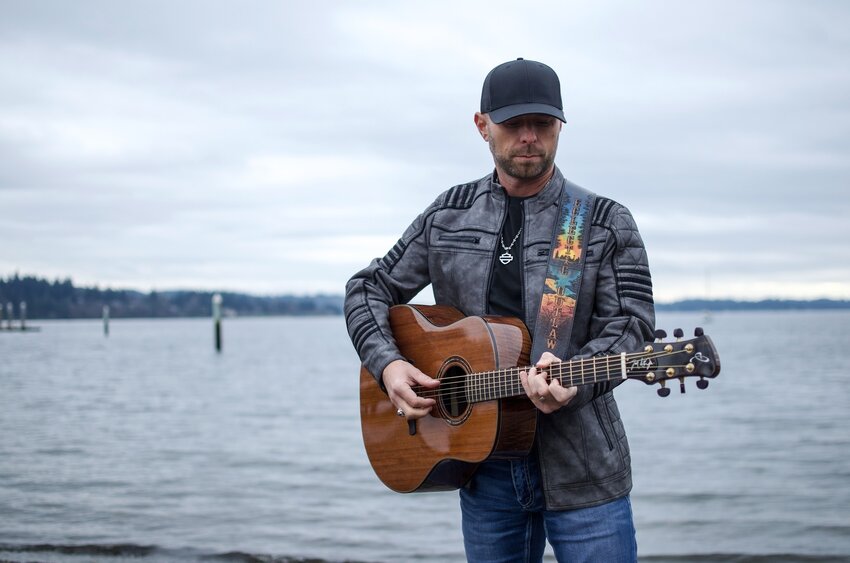 Country and rock artist Joel Gibson Jr. strums a guitar in this photo from his website.