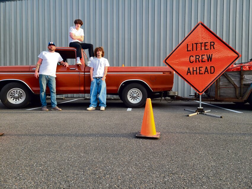 From left: Kyle Scharpf, Kaleb Osborne and Chase Langton pose for a photo with their litter crew signage on Sept. 1.