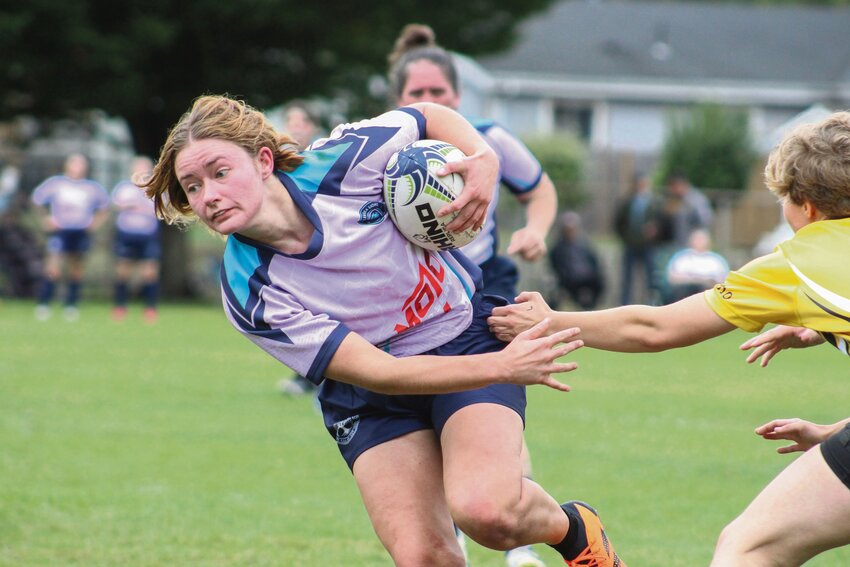 Sage Pavey, a member of the Steller Rugby Club, squeezes past a Tacoma Sirens defender at Portland Avenue Park in Tacoma on Sept. 14.