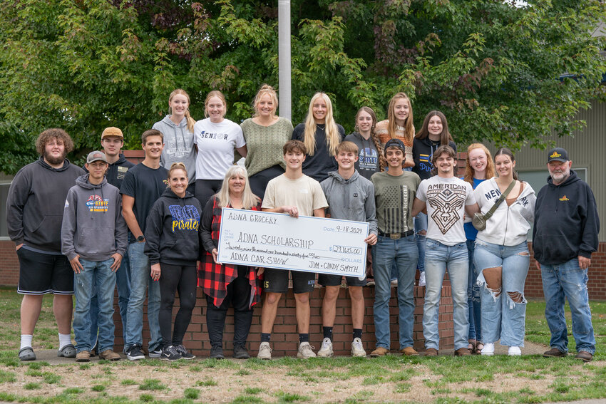 Adna seniors smile for a photo with a check for $29,165 raised by the Adna Car Show for the Adna Scholarship Fund. The check was presented by Jim Smith, far right, and Cindy Smith, in red, at Adna High School on Wednesday, Sept. 18.