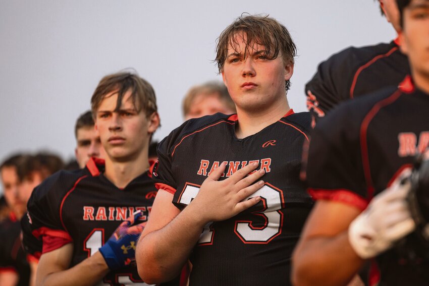 Rainier’s Thomas Roland holds his hand over his heart during the National Anthem during a week one football game at Rainier High School on Friday, Sept. 6.