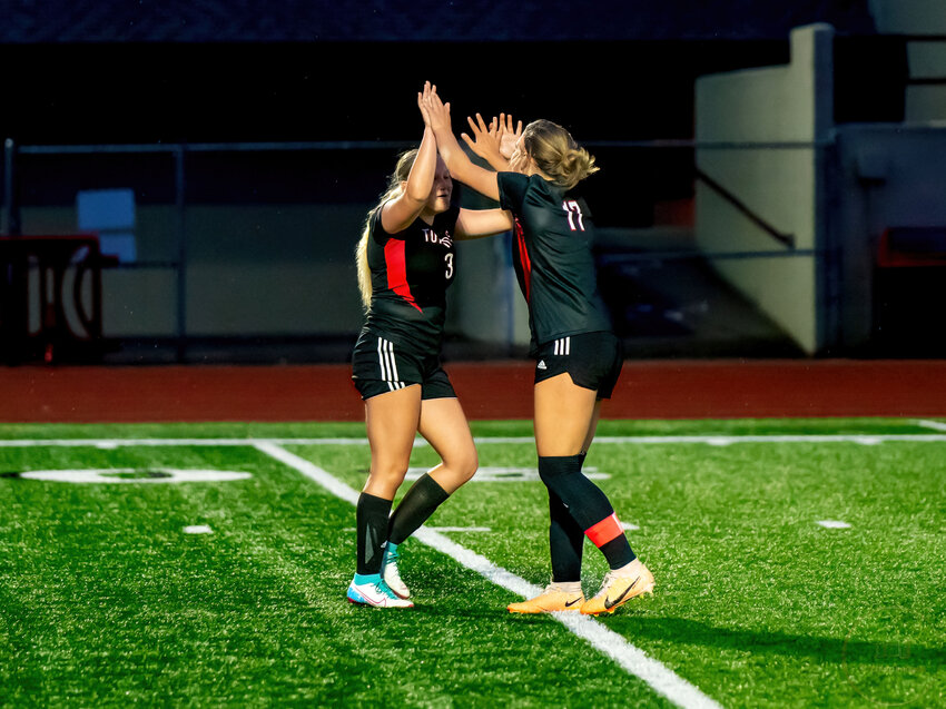 Senior Mariah Arnestad, 3, high fives her senior teammate Holly Dorhauer, 17, in a contest against Mount Tahoma.