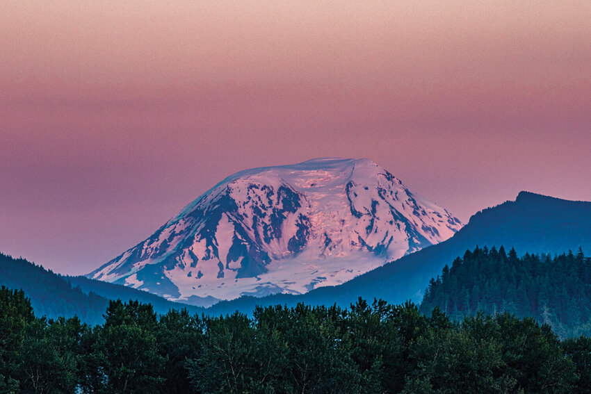 Mount Adams glows pink in the alpenglow at sunset on Saturday, July 6, as seen from Peters Road in Randle.