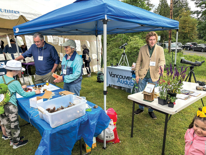 Participants of the Vancouver Audubon Young Birders Club use binoculars to spot birds during a field trip. Locals can learn more about the club and bird-spotting tips at the World Migratory Bird Day celebration held by Vancouver Audubon.