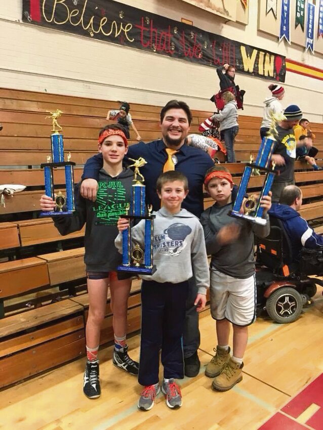 Ben Hawk poses with several of his young former athletes at a tournament. He will coach his first season in 2024-25 as Yelm High School&rsquo;s girls wrestling coach.