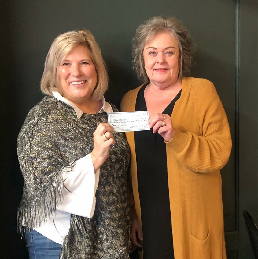 Kris Camenzind, executive director of the Hope Alliance of Lewis County, left, receives a check for $1,100 from Centralia Girls Night Out representative Sandi Walczyk this week.